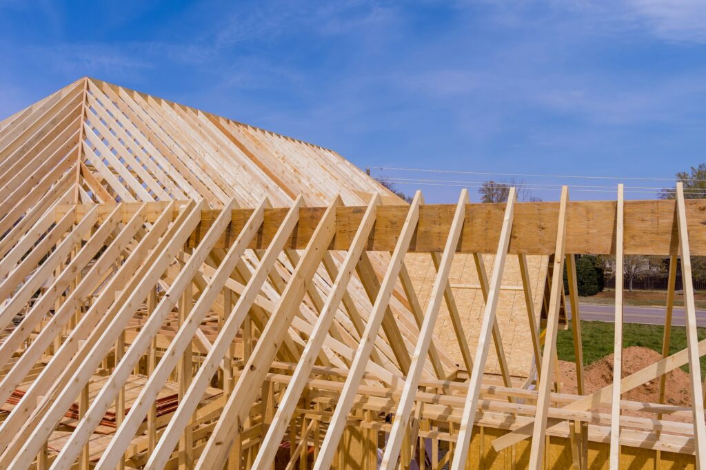 Beams roof trusses frame an exterior view of a framed building construction