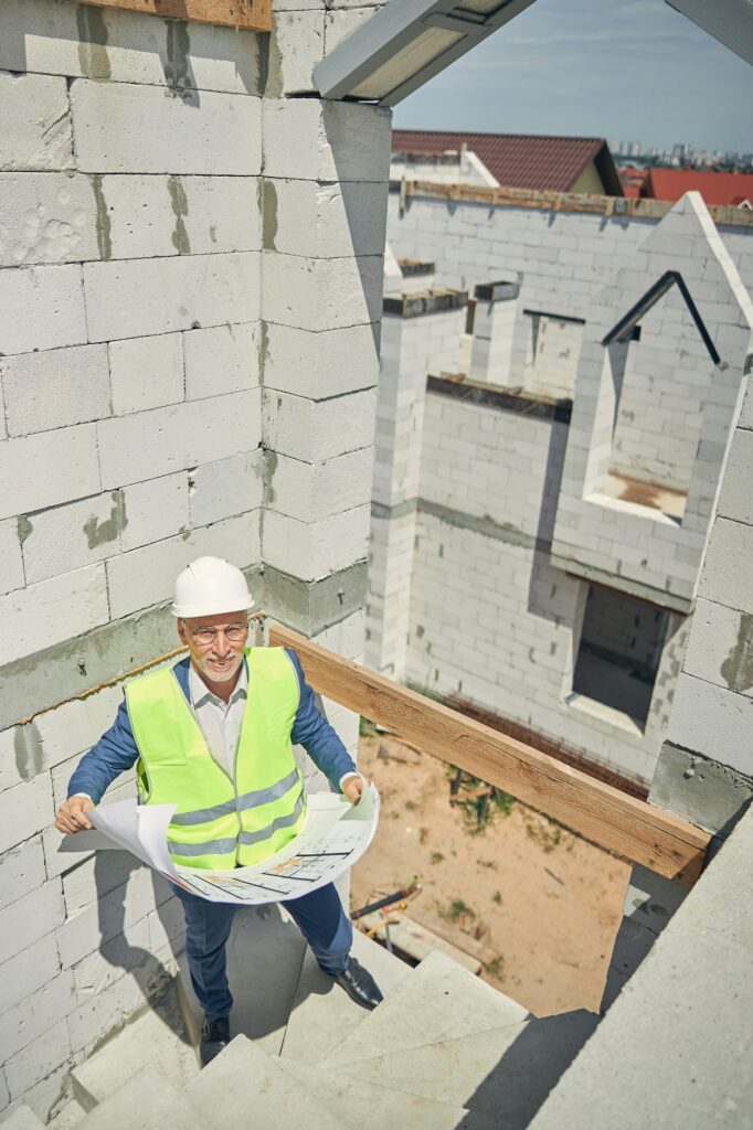 Caucasian male worker standing on the spiral stairs