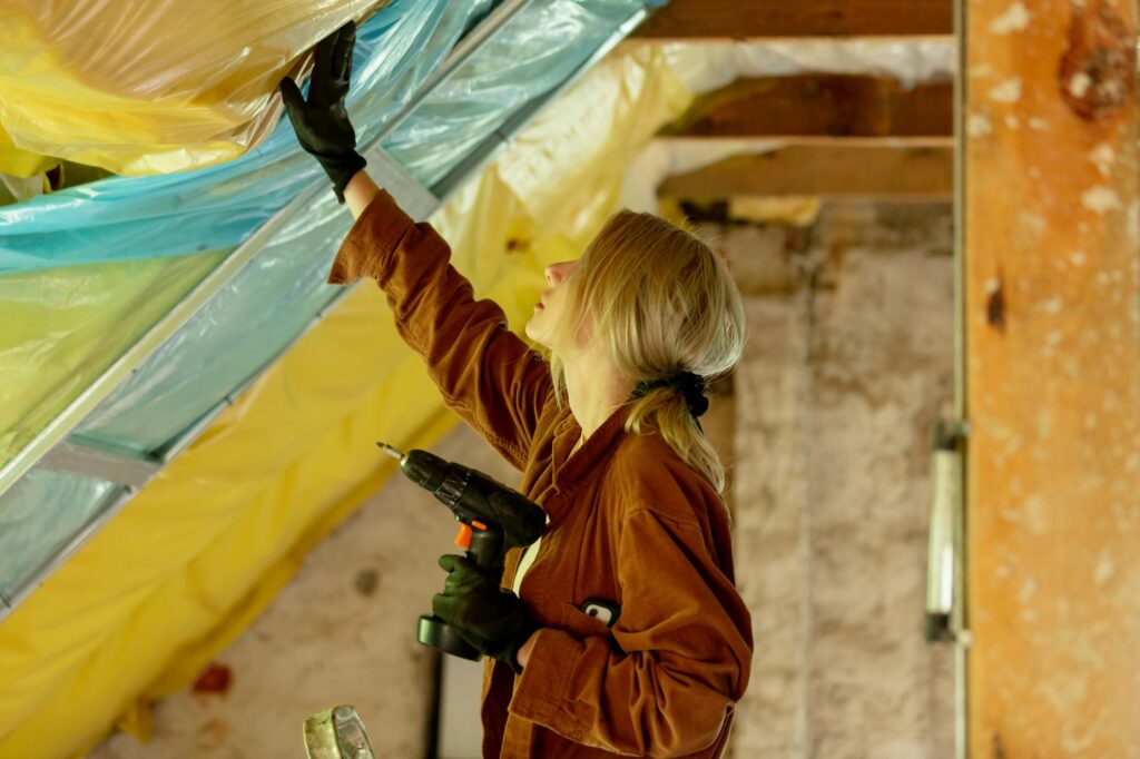 Woman with screwdriver fix roof in home